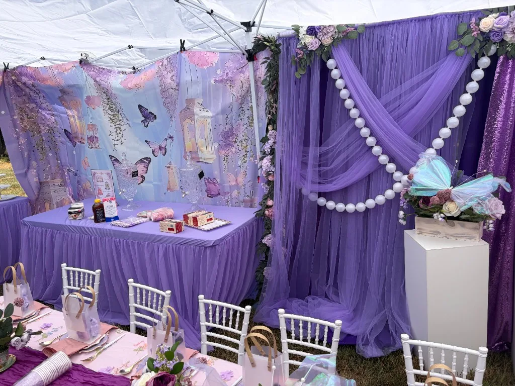 Tent interior with fairy-tale backdrop, lavender draping, sequin panel, and children's place settings