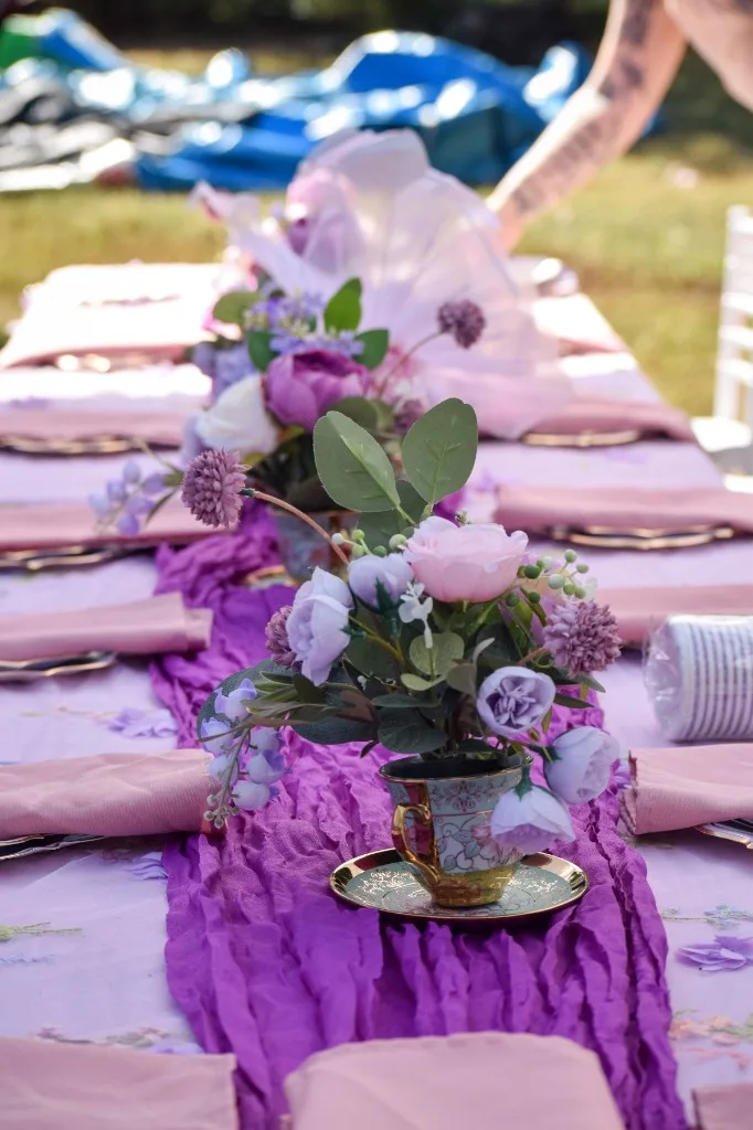 Vintage teacup floral centerpiece on a textured purple gauze runner