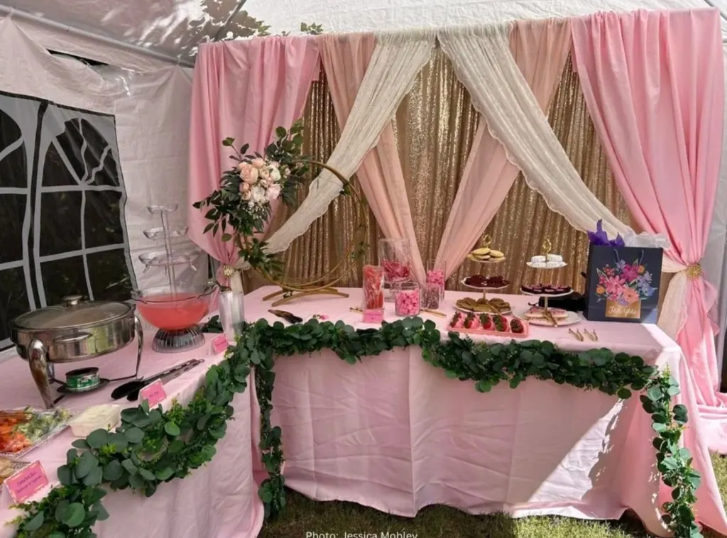 Pink dessert and buffet table with gold sequin backdrop, florals, and eucalyptus garland
