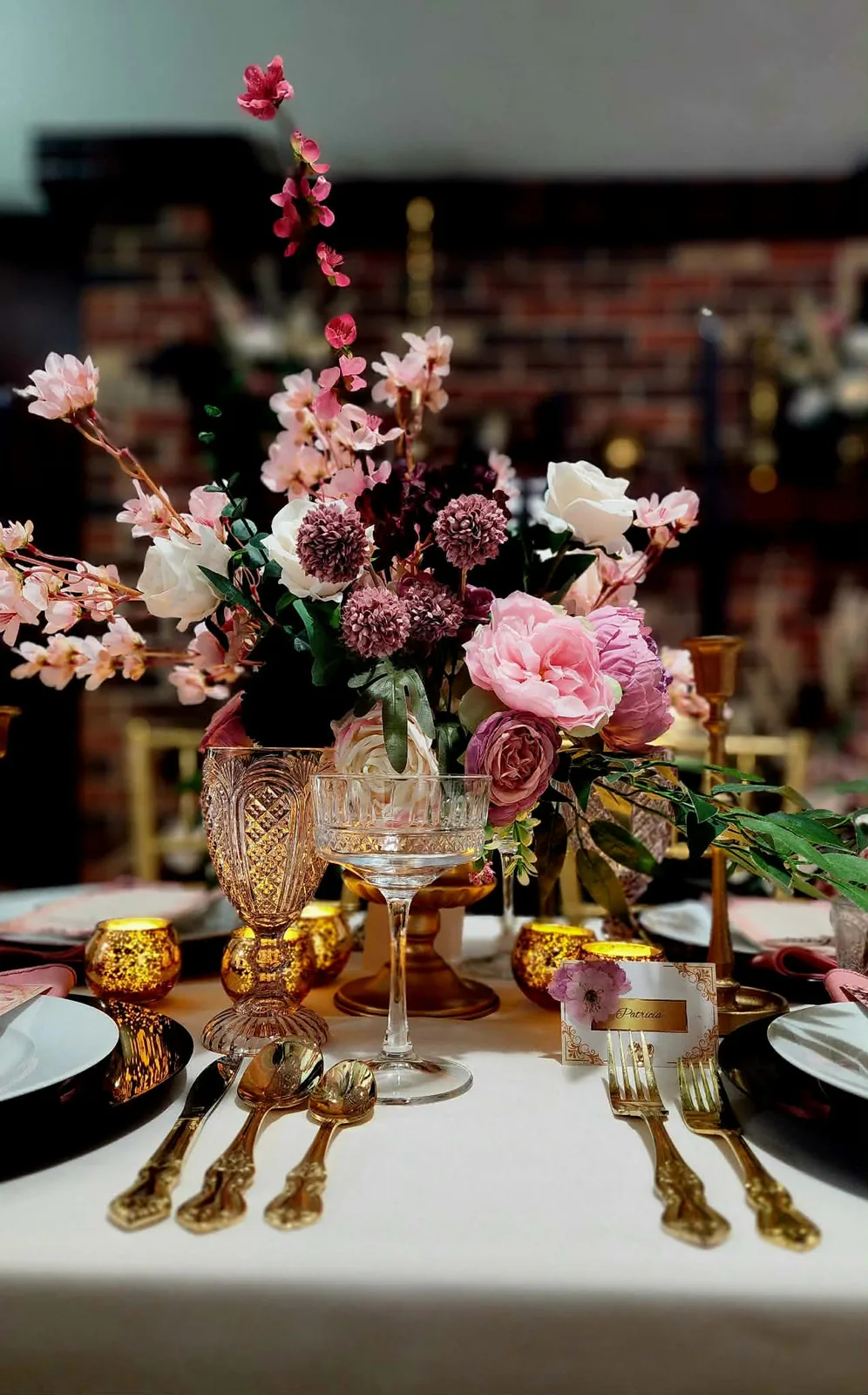 Cherry blossom and rose centerpiece with vintage glassware, gold votives, and place card